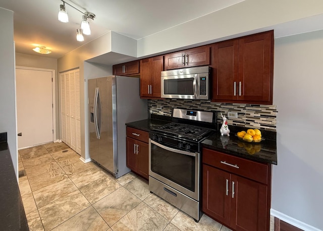 kitchen with dark stone counters, baseboards, decorative backsplash, and stainless steel appliances
