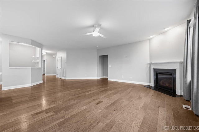 719 Foxborough Rd, South Elgin, IL 60177 - unfurnished living room featuring a ceiling fan, a glass covered fireplace, wood finished floors, and baseboards
