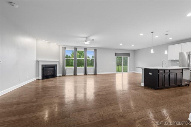 719 Foxborough Rd, South Elgin, IL 60177 - unfurnished living room with a glass covered fireplace, recessed lighting, baseboards, wood finished floors, and a ceiling fan