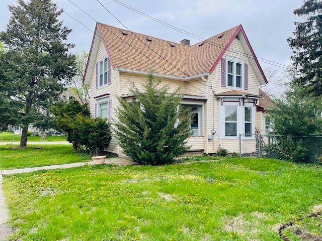 242 N Grove St, Carpentersville, IL 60110 - view of home's exterior featuring fence, a shingled roof, and a lawn