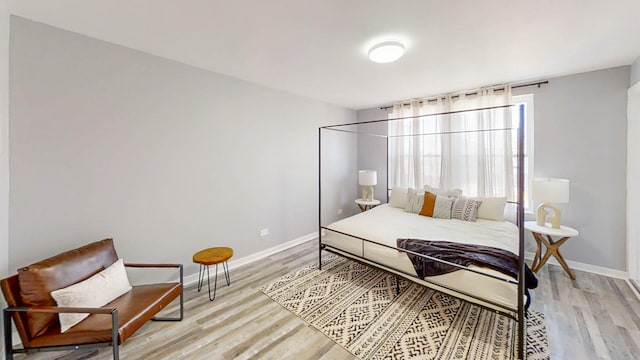 bedroom featuring baseboards and light wood finished floors