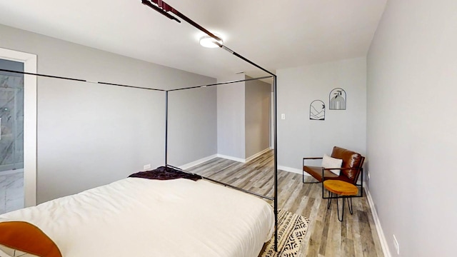 bedroom with baseboards and wood finished floors