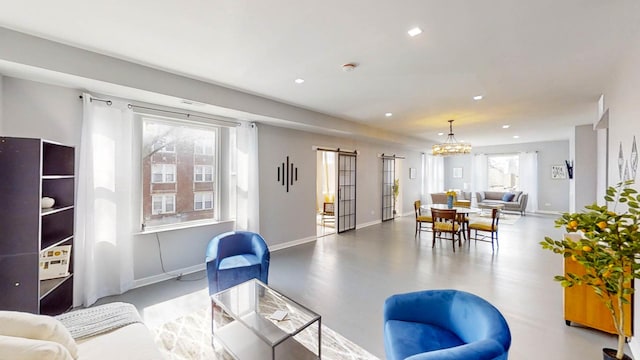 living area with an inviting chandelier, a barn door, baseboards, and recessed lighting