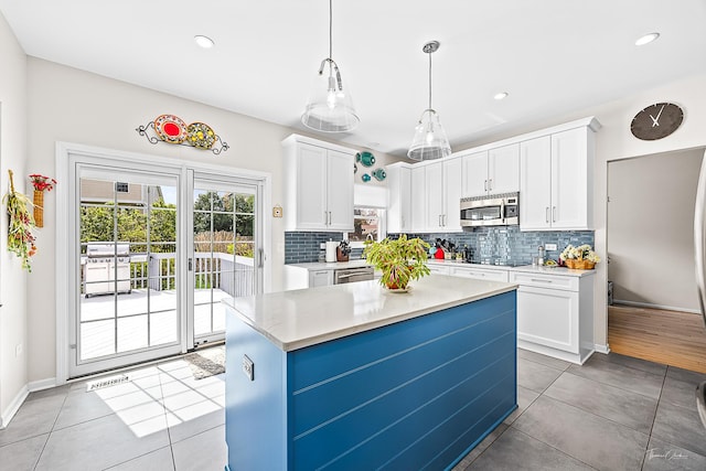 849 Brompton Cir, Bolingbrook, IL 60440 - kitchen with stainless steel microwave, white cabinetry, light countertops, decorative backsplash, and recessed lighting