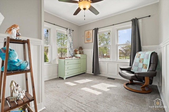 309 E Elm St, Villa Park, IL 60181 - living area featuring a wainscoted wall, a ceiling fan, a decorative wall, and light colored carpet