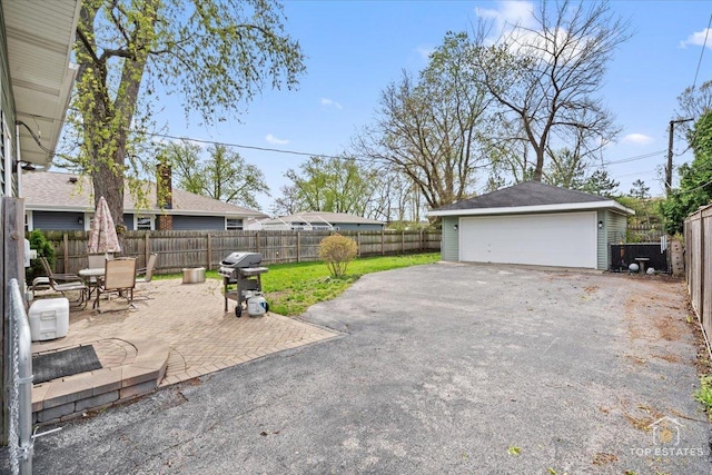 309 E Elm St, Villa Park, IL 60181 - view of patio / terrace with outdoor dining space, a garage, area for grilling, a fenced backyard, and an outdoor structure