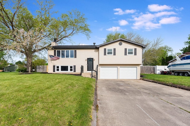 split foyer home featuring a front lawn, fence, a chimney, an attached garage, and driveway
