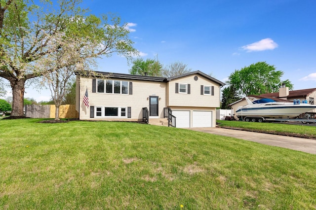 raised ranch featuring fence, concrete driveway, a front yard, and a garage