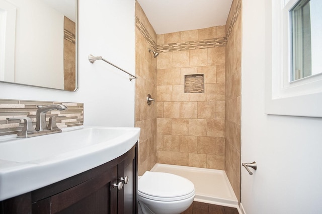 full bathroom with vanity, tasteful backsplash, a tile shower, and toilet