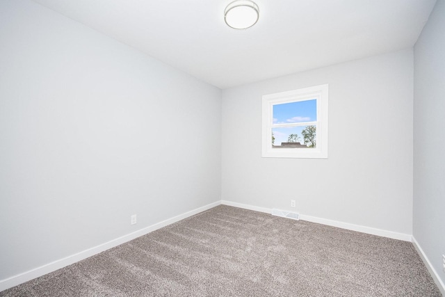 carpeted empty room featuring visible vents and baseboards