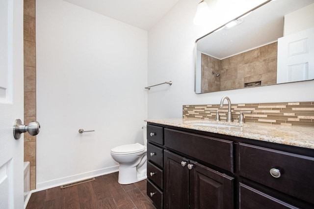 full bath featuring decorative backsplash, visible vents, wood finished floors, vanity, and toilet
