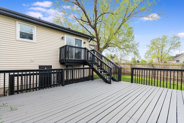 wooden terrace featuring a fenced backyard and stairway