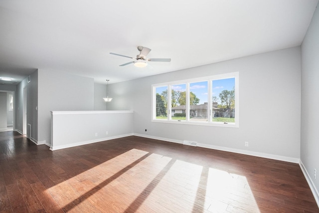 spare room with visible vents, dark wood-style flooring, ceiling fan, and baseboards