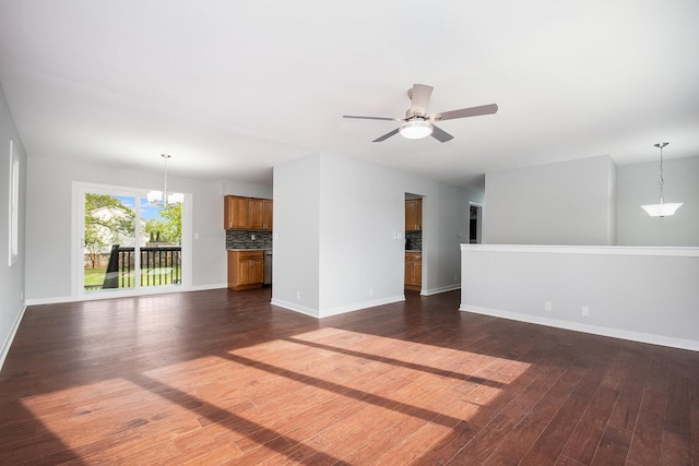 unfurnished living room with baseboards, ceiling fan with notable chandelier, and dark wood finished floors