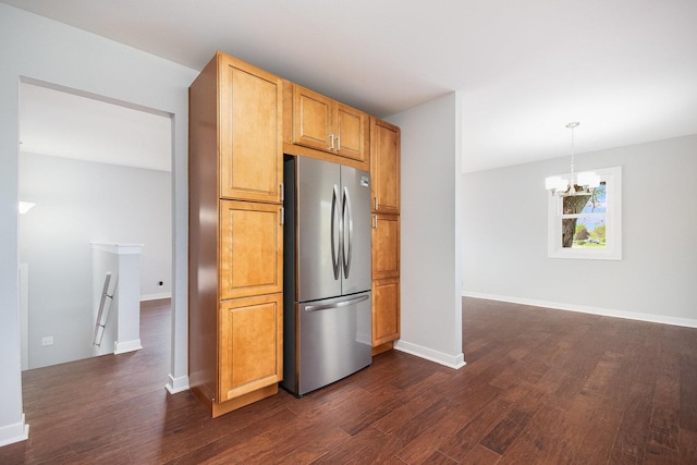 kitchen with an inviting chandelier, hanging light fixtures, freestanding refrigerator, and dark wood-style flooring