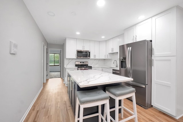 7330 Fairview Ave Unit 104, Downers Grove, IL 60516 - kitchen featuring light wood-style floors, white cabinetry, appliances with stainless steel finishes, and a kitchen island