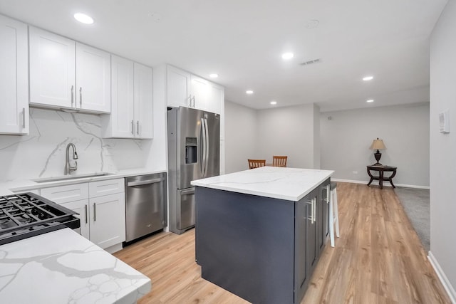 7330 Fairview Ave Unit 104, Downers Grove, IL 60516 - kitchen featuring a kitchen island, appliances with stainless steel finishes, a sink, white cabinets, and recessed lighting