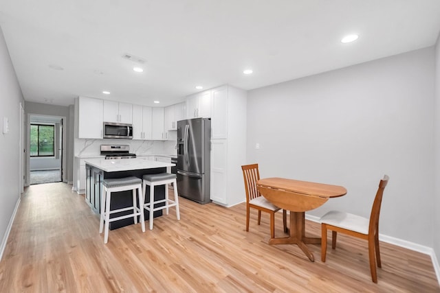 7330 Fairview Ave Unit 104, Downers Grove, IL 60516 - kitchen featuring white cabinets, light countertops, stainless steel appliances, a kitchen island, and visible vents