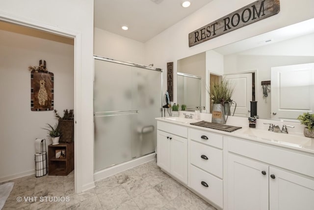 bathroom featuring a shower stall, double vanity, recessed lighting, and baseboards
