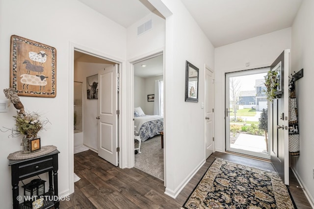 entrance foyer with dark wood-type flooring and baseboards