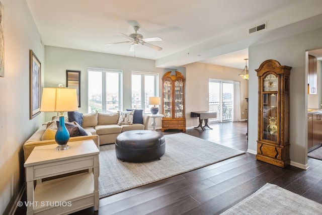 living room with visible vents, a ceiling fan, dark wood finished floors, and baseboards