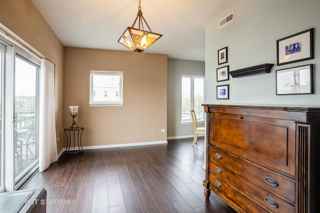 interior space featuring visible vents, baseboards, and dark wood finished floors