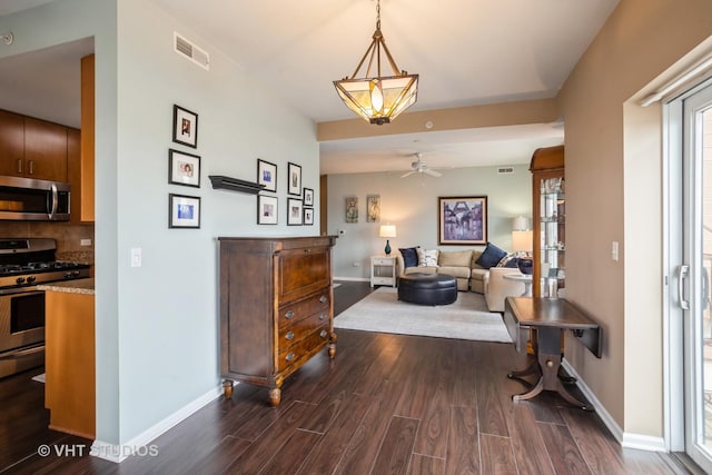 hallway with baseboards, dark wood finished floors, and visible vents