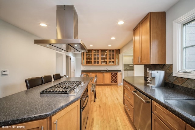 3935 Russett Ln, Northbrook, IL 60062 - kitchen with island range hood, dark countertops, a sink, glass insert cabinets, and stainless steel appliances