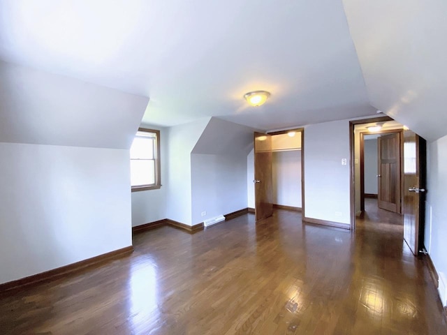 bonus room featuring baseboards, dark wood-style flooring, lofted ceiling, and visible vents