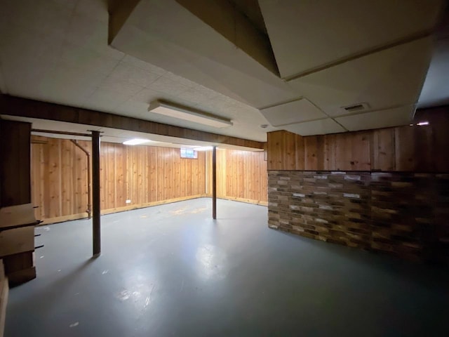 finished below grade area featuring wood walls