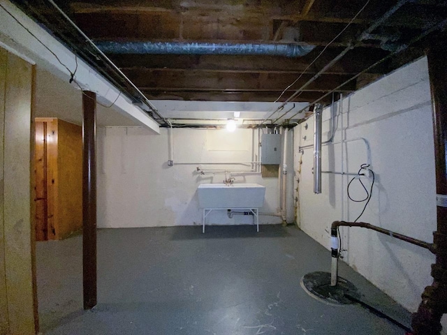 unfinished basement with a sink and electric panel