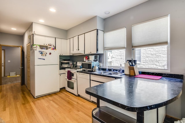 1538 W Fry St, Chicago, IL 60642 - kitchen with dark countertops, light wood-type flooring, a sink, white appliances, and white cabinetry