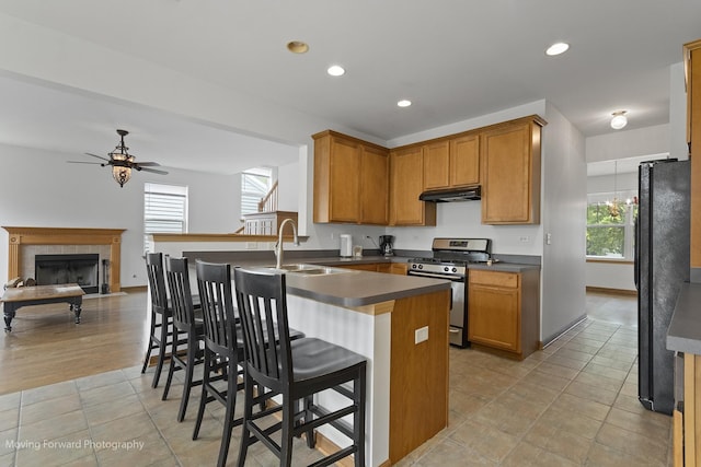 3149 Primrose St, Elgin, IL 60124 - kitchen with gas range, freestanding refrigerator, under cabinet range hood, dark countertops, and a ceiling fan