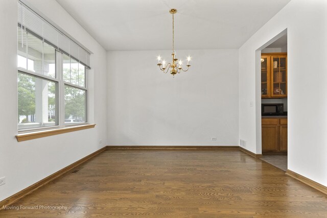 3149 Primrose St, Elgin, IL 60124 - unfurnished room with dark wood-style floors and a chandelier