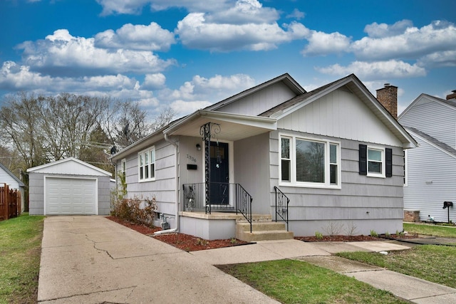 view of front of home with a detached garage, board and batten siding, driveway, and an outdoor structure