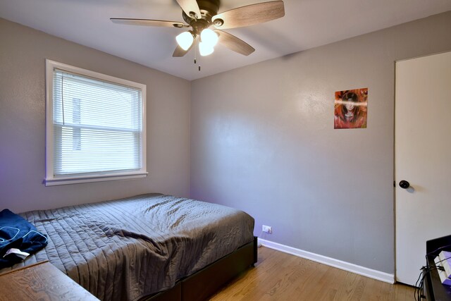 bedroom with baseboards, ceiling fan, and light wood-style flooring