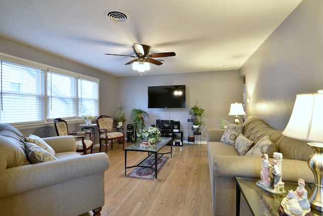 living area with visible vents, light wood-style flooring, and ceiling fan