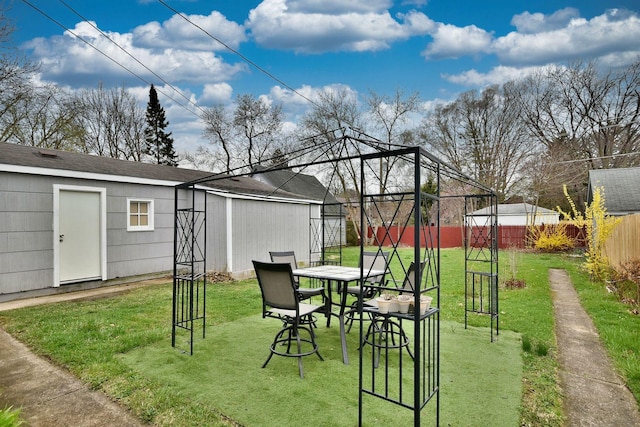 view of yard with a fenced backyard, an outdoor structure, and outdoor dining space
