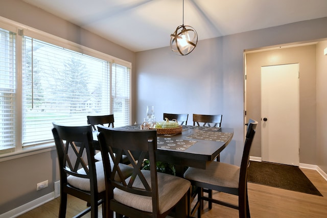 dining space with baseboards, plenty of natural light, and wood finished floors