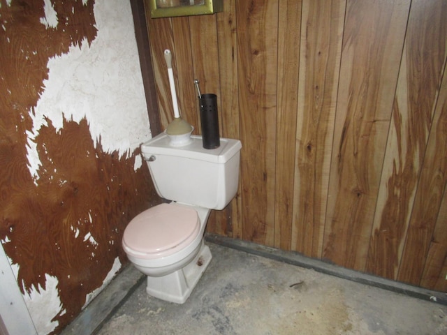 2952 S Bonfield St, Chicago, IL 60608 - bathroom featuring wood walls, toilet, and unfinished concrete flooring