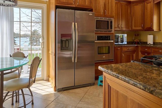 24270 N Forest Dr, Lake Zurich, IL 60047 - kitchen with appliances with stainless steel finishes, brown cabinets, light tile patterned floors, and dark stone countertops