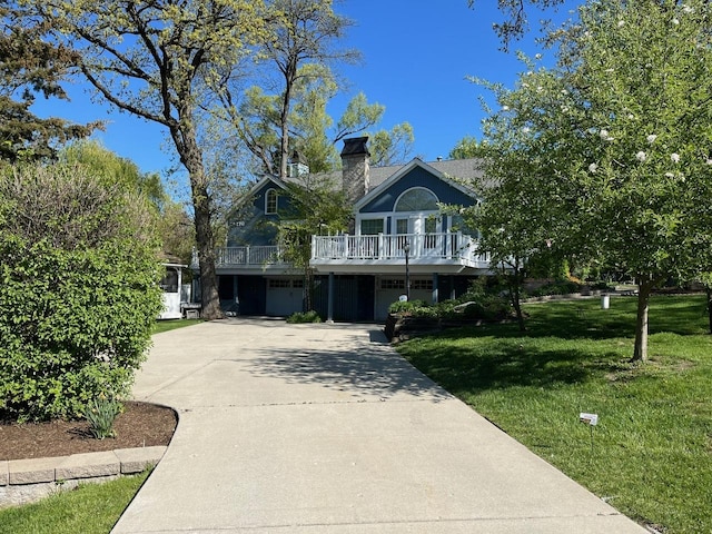 24270 N Forest Dr, Lake Zurich, IL 60047 - view of front facade with a front lawn, concrete driveway, and a chimney