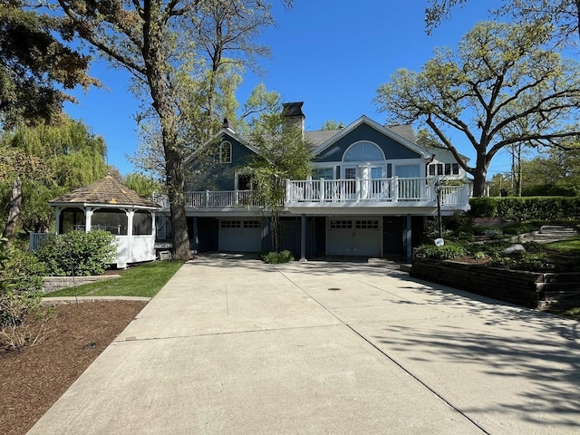 24270 N Forest Dr, Lake Zurich, IL 60047 - view of front facade featuring an attached garage, a gazebo, concrete driveway, and a chimney