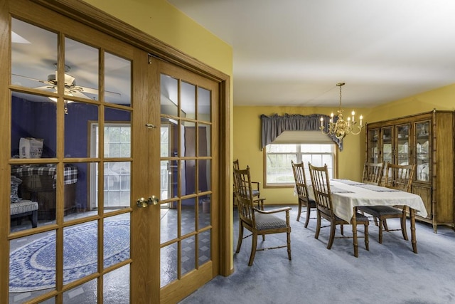 dining space featuring french doors, carpet flooring, and a notable chandelier