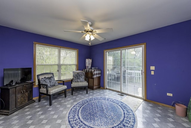 sitting room featuring baseboards, a ceiling fan, and tile patterned floors