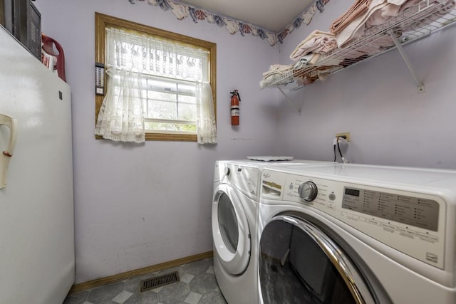 laundry area with baseboards, laundry area, washing machine and dryer, and visible vents