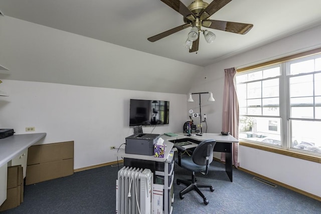 carpeted home office featuring ceiling fan, visible vents, baseboards, and vaulted ceiling