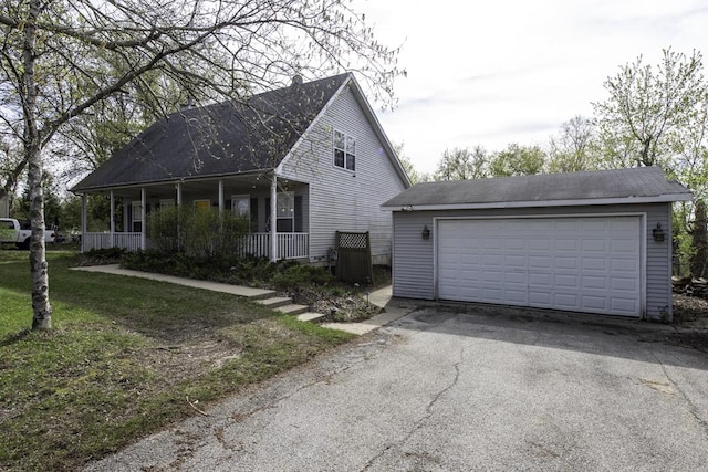 view of home's exterior featuring covered porch, an outbuilding, and a detached garage