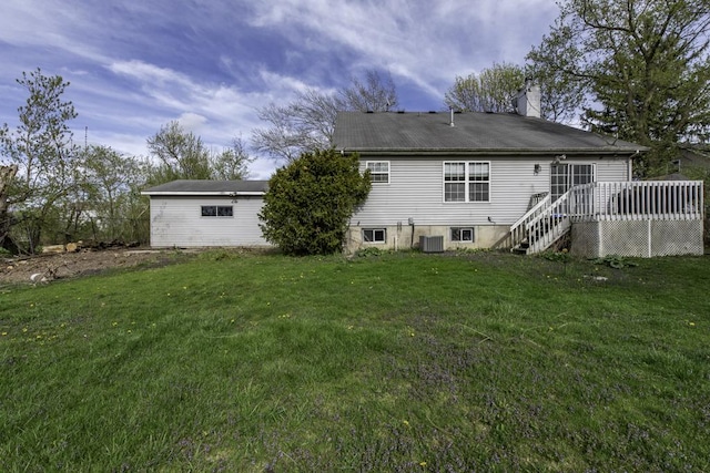 rear view of house with central air condition unit, a yard, a chimney, and a wooden deck