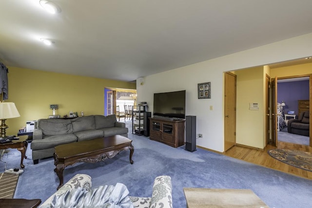 living area with baseboards and carpet